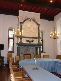 Direct bij binnenkomst merk je dat de Raadszaal van Doesburg al eeuwenlang een belangrijk vertrek moet zijn geweest. Dit komt door de hoogte van ruimte, de imposante eikenhouten balken en de mooie, zeventiende-eeuwse schouw. Wanneer we de schouw beter bekijken, blijkt de eerste indruk juist: de afbeelding van het Salomonsoordeel en de Latijnse tekst verwijzen naar rechtvaardigheid en goed bestuur. Deze onderwerpen waren ook in het verleden al typisch voor de decoratie van stadhuizen.