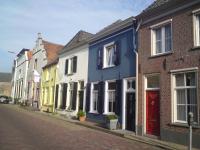 Kleuren ondersteunen parcellering. Plantenbakken op stoepen dragen bij aan groen straatbeeld.