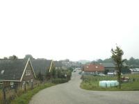 Hoogteverschil goed waarneembaar vanaf de dijk met zicht op de daken en prive-terrein.