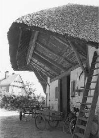 De kenmerkende dakoverstek boven de deuren van de deel.